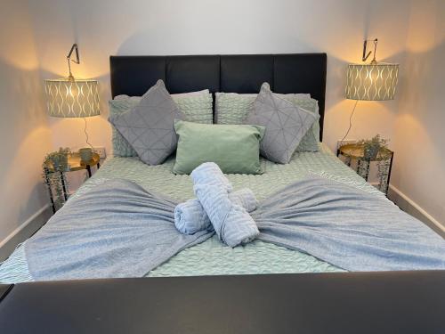 a large bed with a blue comforter and pillows at Cute+Cozy Guesthouse for 2 +secure offroad parking in Fallings Park