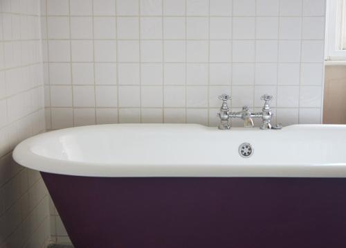 a bathroom with a white tub and a sink at Kings Arms Hotel by Greene King Inns in Westerham