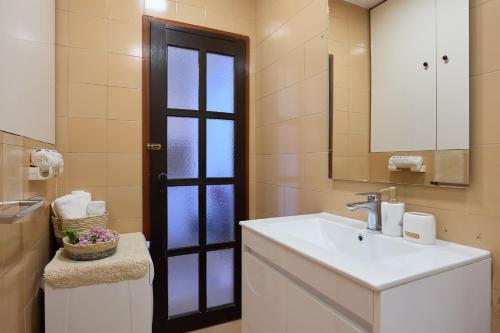 a bathroom with a sink and a mirror and a door at Sunset Oasis in Dubrovnik