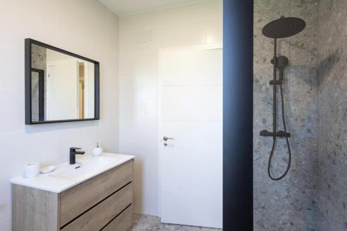 La salle de bains est pourvue d'une douche, d'un lavabo et d'un miroir. dans l'établissement HASTA 16 PERSONAS MIÑO, à Miño