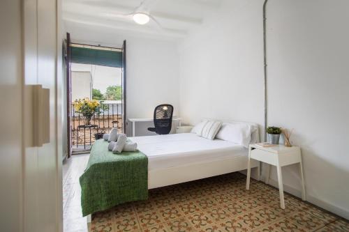 ein Schlafzimmer mit einem weißen Bett und einer grünen Decke in der Unterkunft BBarcelona Sants Flat in Barcelona