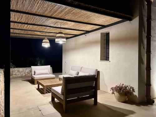 une terrasse avec deux chaises, un canapé et une table dans l'établissement Bimmisca Country House, à Noto