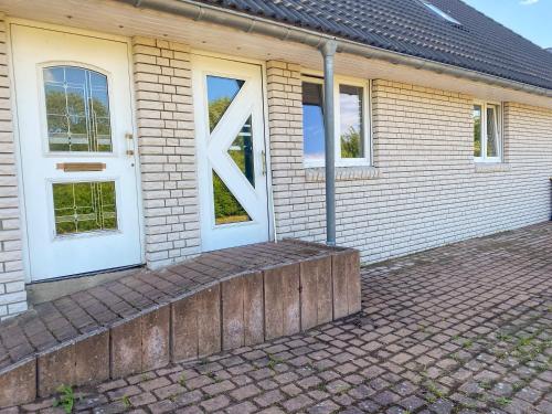 a brick house with a white door and windows at Ferienwohnung Jana in Blankenhagen