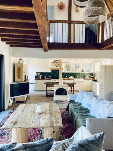 un salon avec un canapé et une table en bois dans l'établissement Maison campagne piscine 1hParis 25m Fontainebleau, à Préaux