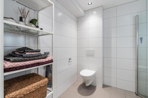 a white bathroom with a toilet and a shower at Brand new in Bergen