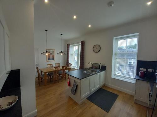 a kitchen and living room with a counter and a table at Stunning Village Centre Holiday Home in Callander