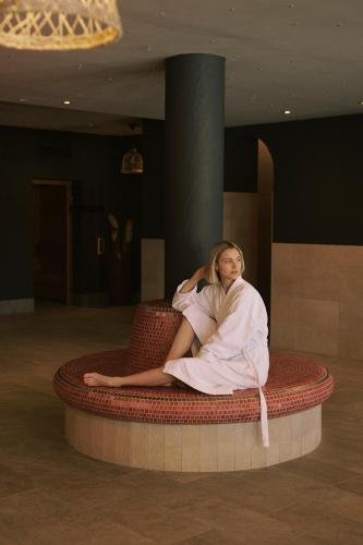 a woman sitting on a bed in a room at SOULSISTERS' Hotel 4 Sterne Superior in Kaprun
