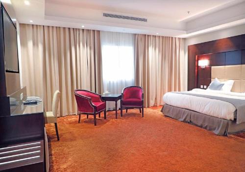 a hotel room with a bed and a table and chairs at ارجان سويت 2 in Jeddah