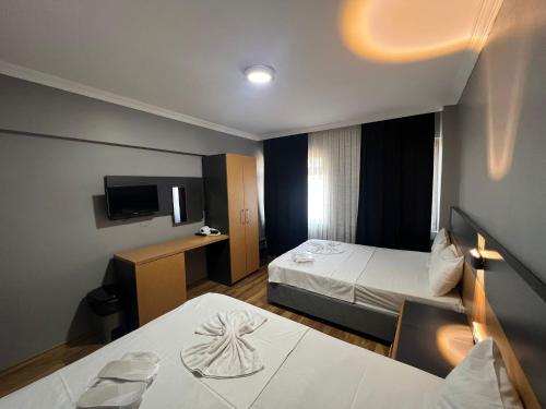 a hotel room with two beds and a television at Hotel Otağ in Istanbul