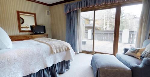 a bedroom with a bed and a tv and a window at Vail Village Plaza Lodge 3 Bedroom Condo in Vail