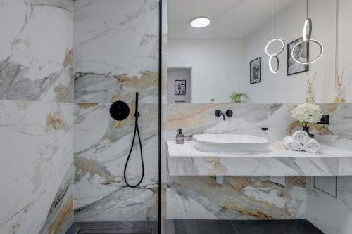 Łazienka z umywalką i marmurową ścianą w obiekcie Beachfront Apartment Split w Splicie