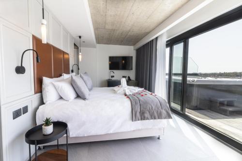 a bedroom with a large bed and a balcony at The Londoner Hotel Sliema in Sliema