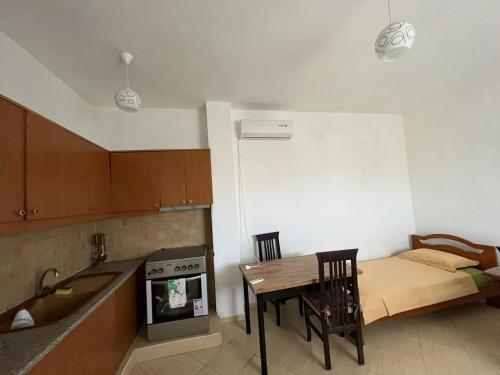 a kitchen with a table and a bed in it at Laert's Home in Sarandë