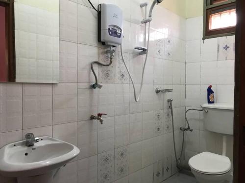 ein Bad mit einer Dusche, einem WC und einem Waschbecken in der Unterkunft BLT Residence - Kasese A serene and tranquil home in Kasese