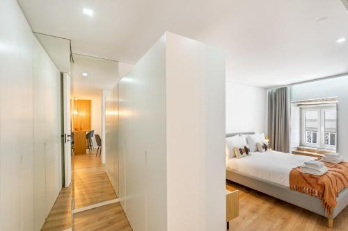 - une chambre avec un lit et un grand miroir dans l'établissement Sé Apartamentos - Dom Miguel Apartment, à Braga