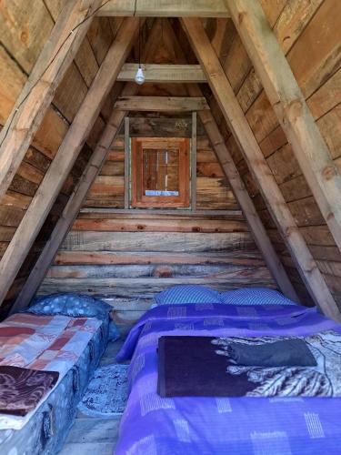 two beds in the attic of a log cabin at Mountain cottage Captain's Lake, Kapetanovo jezero in Kolašin