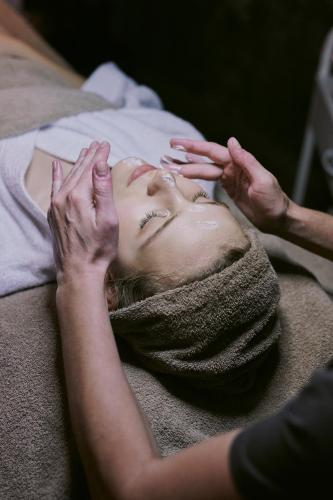 a woman laying on a bed with her face in a towel at SOULSISTERS' Hotel 4 Sterne Superior in Kaprun