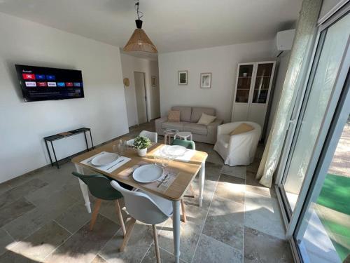 un salon avec une table, des chaises et un canapé dans l'établissement La Bastide de Lolig - CLIM - WiFi, à Sarrians