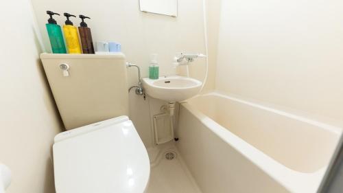 een witte badkamer met een toilet en een wastafel bij FLY CAT HOTEL in Minokamo