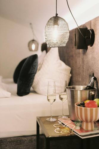 a table with two wine glasses and a bowl of fruit at SOULSISTERS' Hotel 4 Sterne Superior in Kaprun