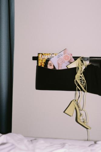 a shelf with a magazine and a pair of shoes at SOULSISTERS' Hotel 4 Sterne Superior in Kaprun