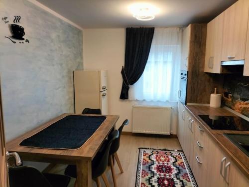 uma pequena cozinha com uma mesa e um frigorífico em Apartament Ary em Borşa