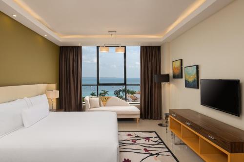 a hotel room with a bed and a flat screen tv at Element by Westin Hotel Dar es Salaam in Dar es Salaam