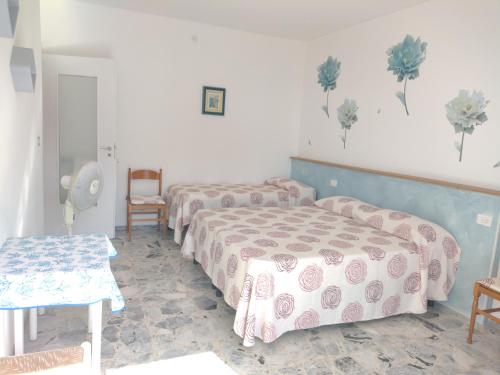 a bedroom with three beds and a table at CASA FRONTE MARE in Ventimiglia