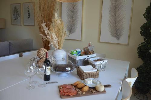 a white table with wine glasses and food on it at Mar de Fulles in Buarcos