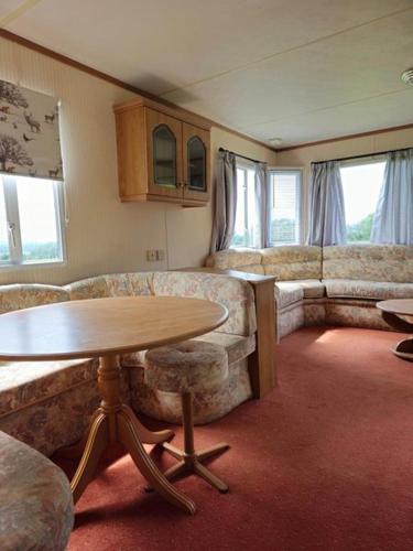 uma sala de estar com uma mesa e um sofá em Y Golygfa em Sarnau