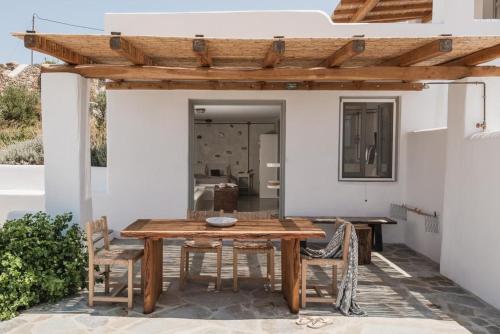 einen Holztisch und Stühle auf einer Terrasse in der Unterkunft Villa Mousa in Mikri Vigla
