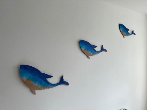 a group of three dolphins on a wall at El Sea House in Chapel Saint Leonards