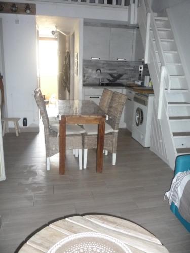une cuisine et une salle à manger avec une table et des chaises dans l'établissement Coquet appartement à quelques pas de la mer, au Grau-dʼAgde