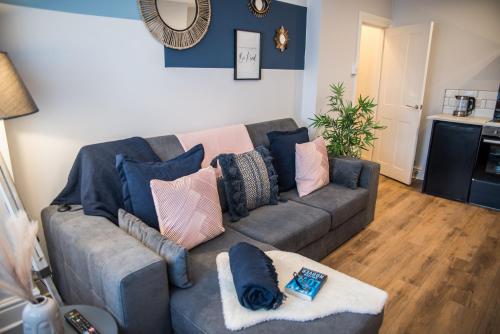 a living room with a couch with pillows on it at Blackpool Abode - Beach Suite Apartment in Blackpool