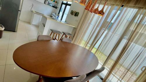 einen Holztisch in einer Küche mit Stühlen in der Unterkunft Morib Homestay Near Gold Coast for Big Family and Golfer in Banting