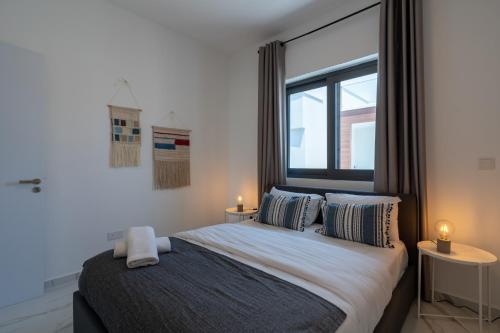 - une chambre avec un lit, 2 tables et une fenêtre dans l'établissement Yasou 1- Bedroom Apartment in Larnaca, à Larnaka