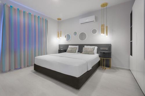 1 dormitorio con cama blanca y cortina colorida en Bayram Apart Hotel, en Alanya