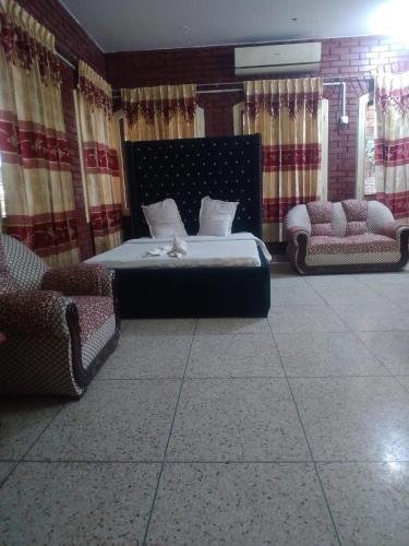 a bedroom with a bed and two chairs at Hotel Western Planet in Dhaka