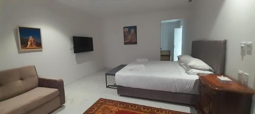 a bedroom with a bed and a chair and a couch at Areni Lodge in Areni