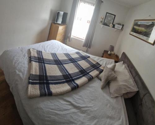 - une chambre avec un lit, une couverture et une fenêtre dans l'établissement Cierons château, à Derry Londonderry