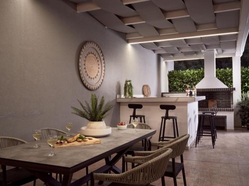 a dining room with a table and chairs with wine glasses at Jasmine Suites with Private Pool in Tsilivi