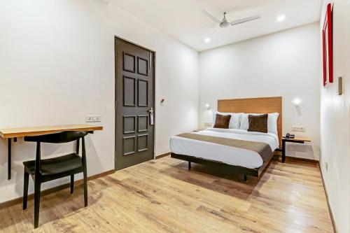 a bedroom with a bed and a desk and a table at Super Townhouse 070 Knowledge Park ||| Near Sharda University in Greater Noida