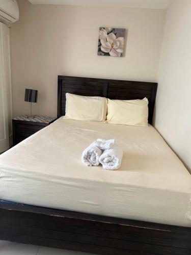 a bed with a pile of towels on it at Bayfront Villa & Apartment in Portmore