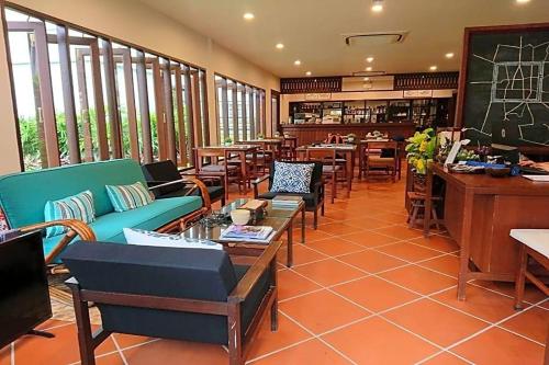 a restaurant with couches and tables and a bar at Villa Sanpakoi in Chiang Mai