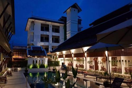 a hotel with a pool in front of a building at Villa Sanpakoi in Chiang Mai