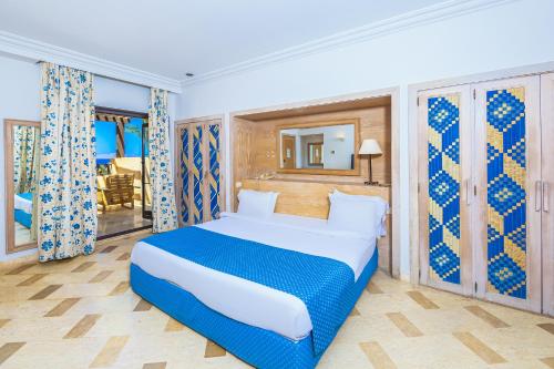 a bedroom with a bed with blue and white sheets at The Grand Hotel Sharm El Sheikh in Sharm El Sheikh