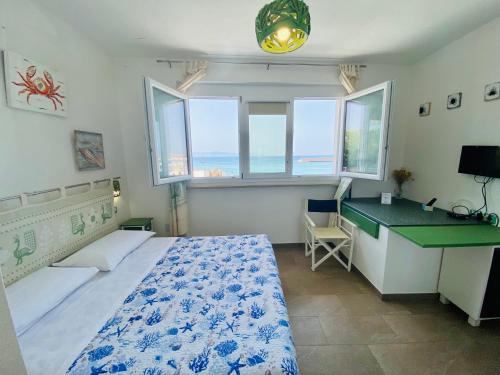 1 dormitorio con 1 cama, escritorio y ventanas en Casetta al mare, en Isola Rossa
