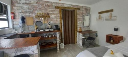 a kitchen with a stove and a stone wall at Revive Self catering unit in Darling