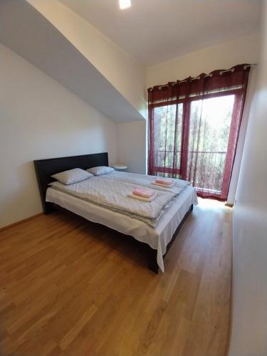 a bedroom with a bed and a large window at Isco Apartment in Kuressaare