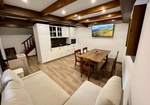 a living room with a table and a dining room at La Casina de la Yeye San Cristóbal de Valdueza in San Cristóbal de Valdueza